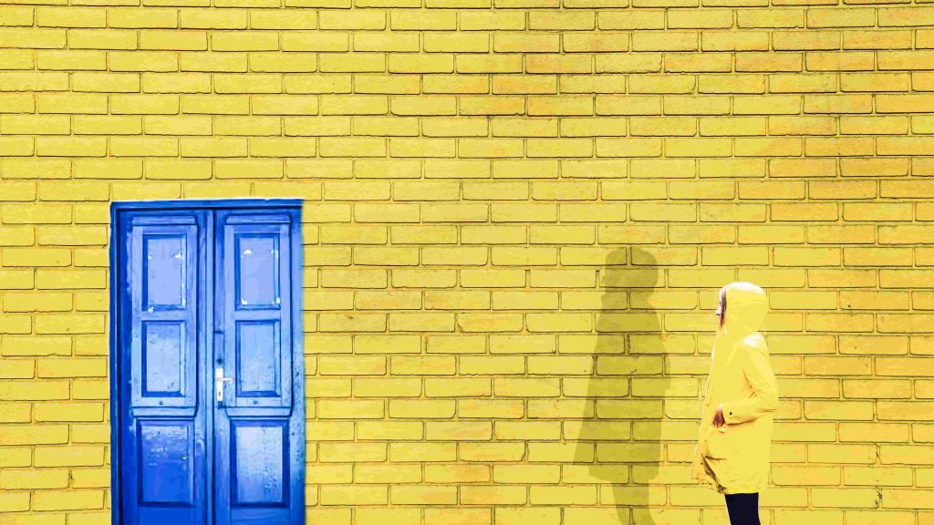 young-women-standing-in-front-of-a-bright-yellow-wall